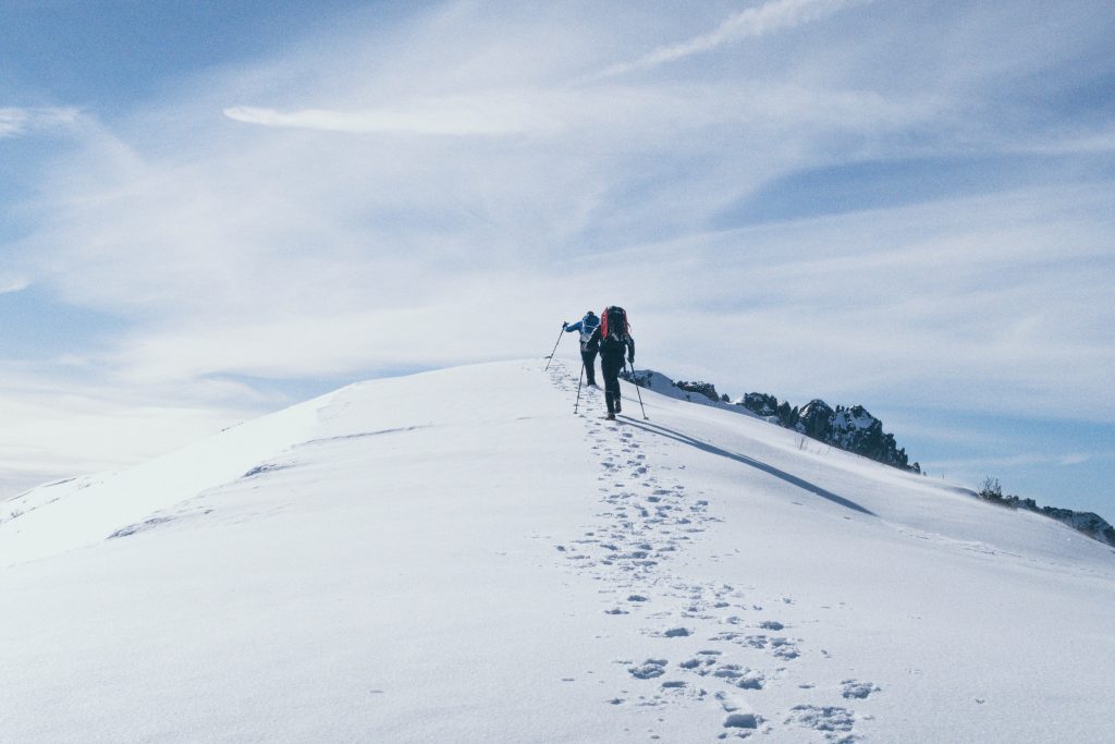 Deux randonneurs qui grimpent une montagne dans la neige