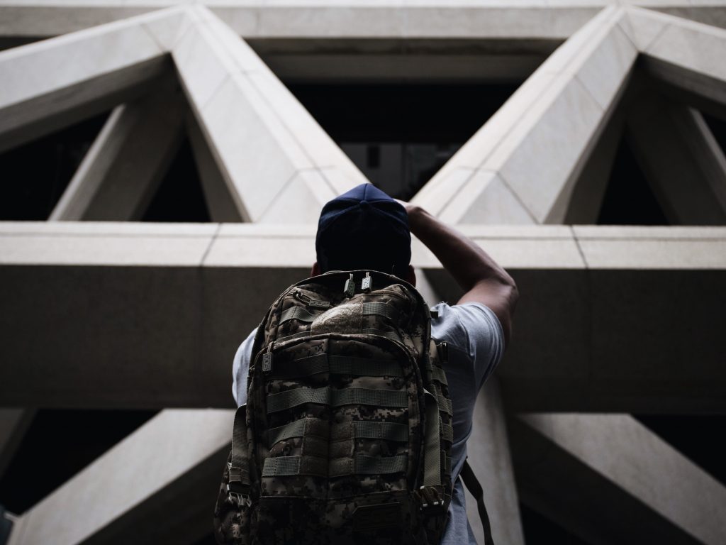 Un photographe devant un batiment en béton